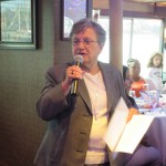 Lady with microphone making announcements at “A Tribute on the Hudson” Luncheon Yacht Cruise