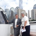Two ladies on the deck of a yacht with NYC skyline behind them