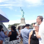 Cabrini attendees in front of Statue of Liberty while riding a yacht on the “A Tribute on the Hudson” Luncheon Yacht Cruise