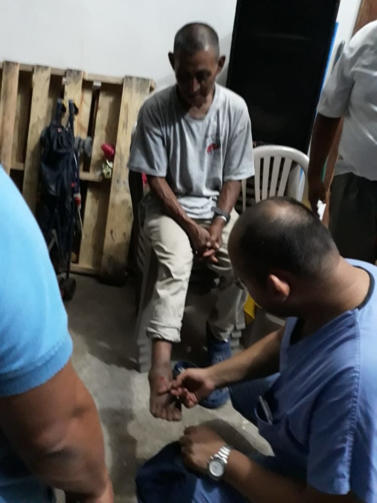 A doctor assists a man with a foot injury