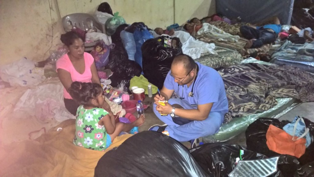 A doctor checks in with a displaced family at Guatemala shelter