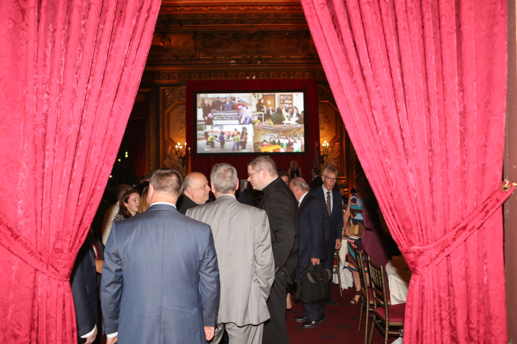Cabrini Mission 20th Anniversary Gala attendees in front of video presentation