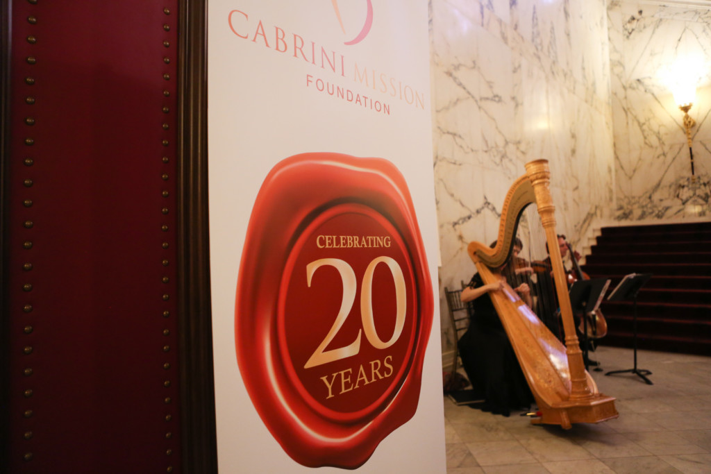 Cabrini Mission 20th Anniversary Gala sign in front of harpist