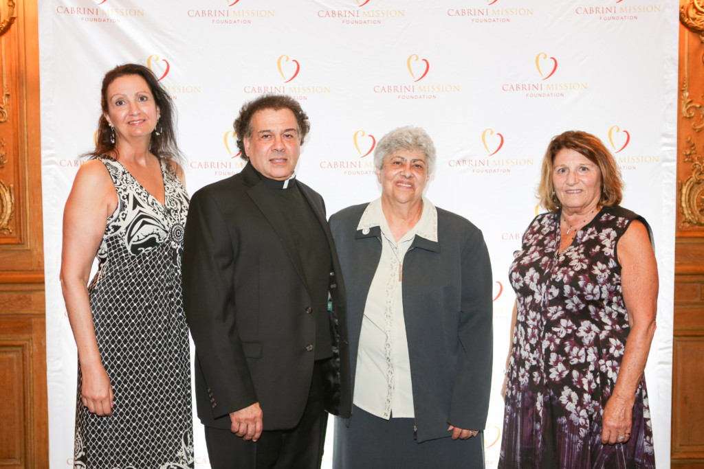 Cabrini Mission 20th Anniversary Gala attendees in front of Cabrini Mission Logo