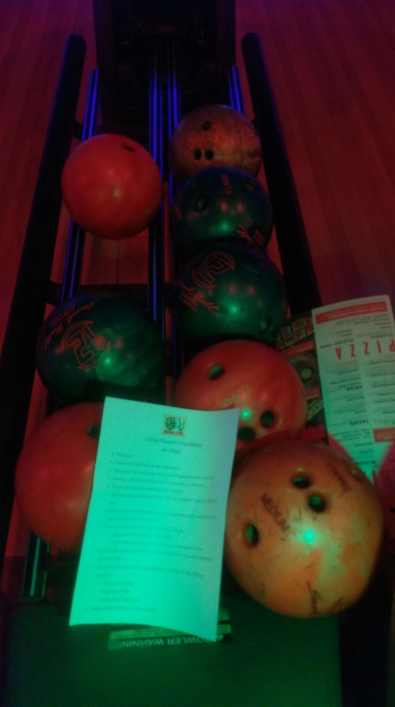 Cabrini Mission 2019 Bowling Event flyer on top of bowling balls