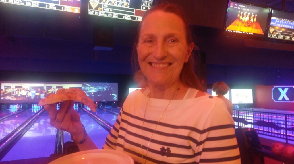 Cabrini Mission Attendee at 2019 Bowling Event holding a slice of pizza