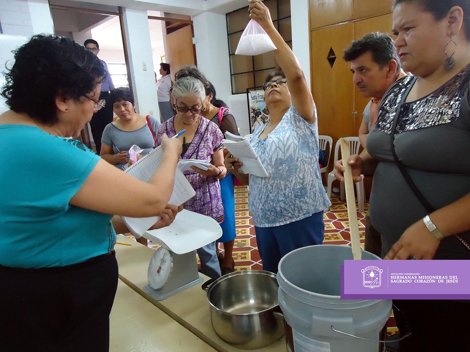 Women gathered at Training Program holding buckets and scales