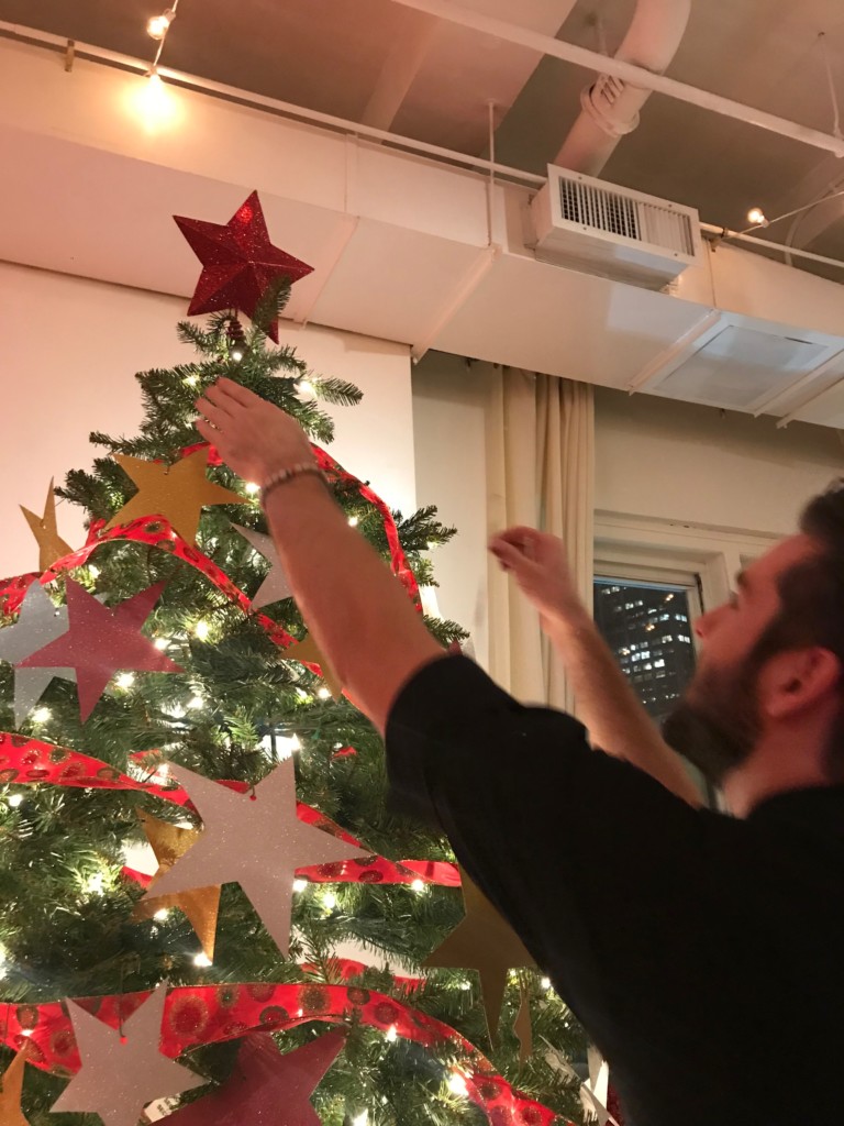 Christmas tree being decorated with ornaments