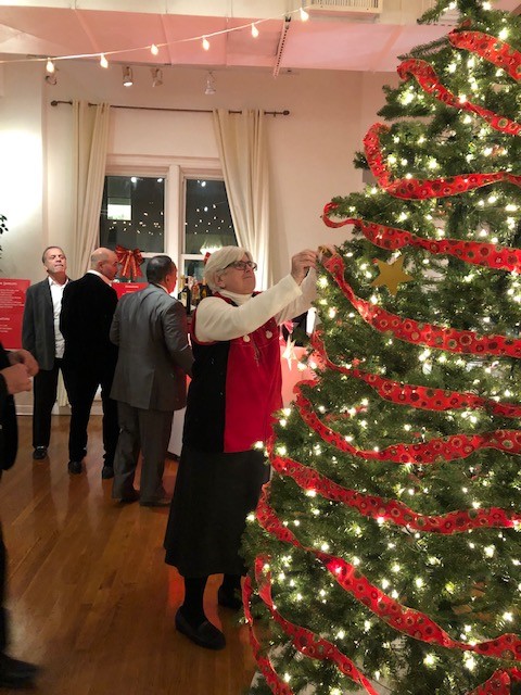 Spirit of Christmas 2019 Attendees placing ornament on christmas tree