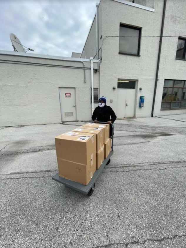 Worker pushing pallet with cardboard boxes