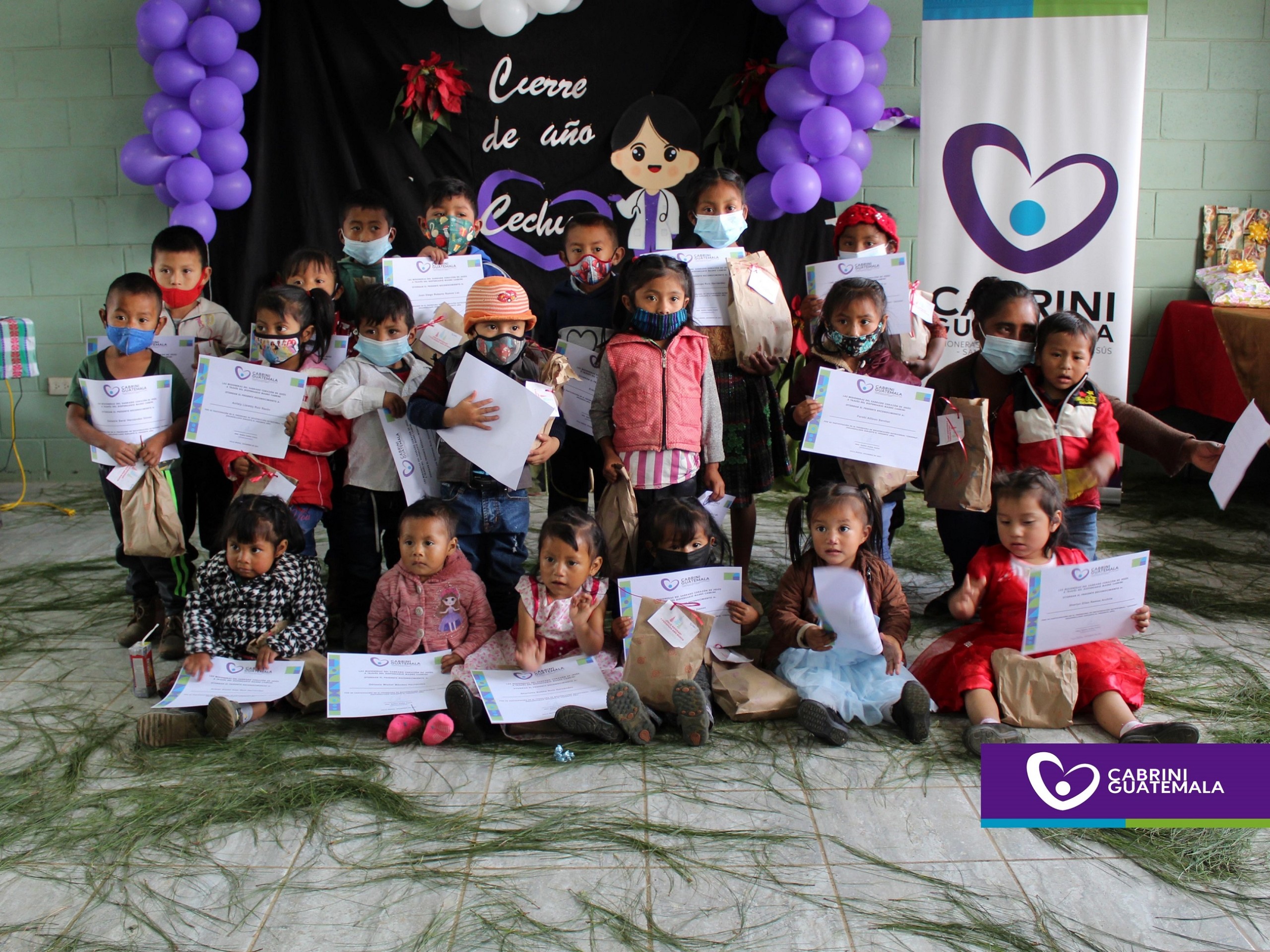 A group of children posing with certificates about Cabrini Guatemala