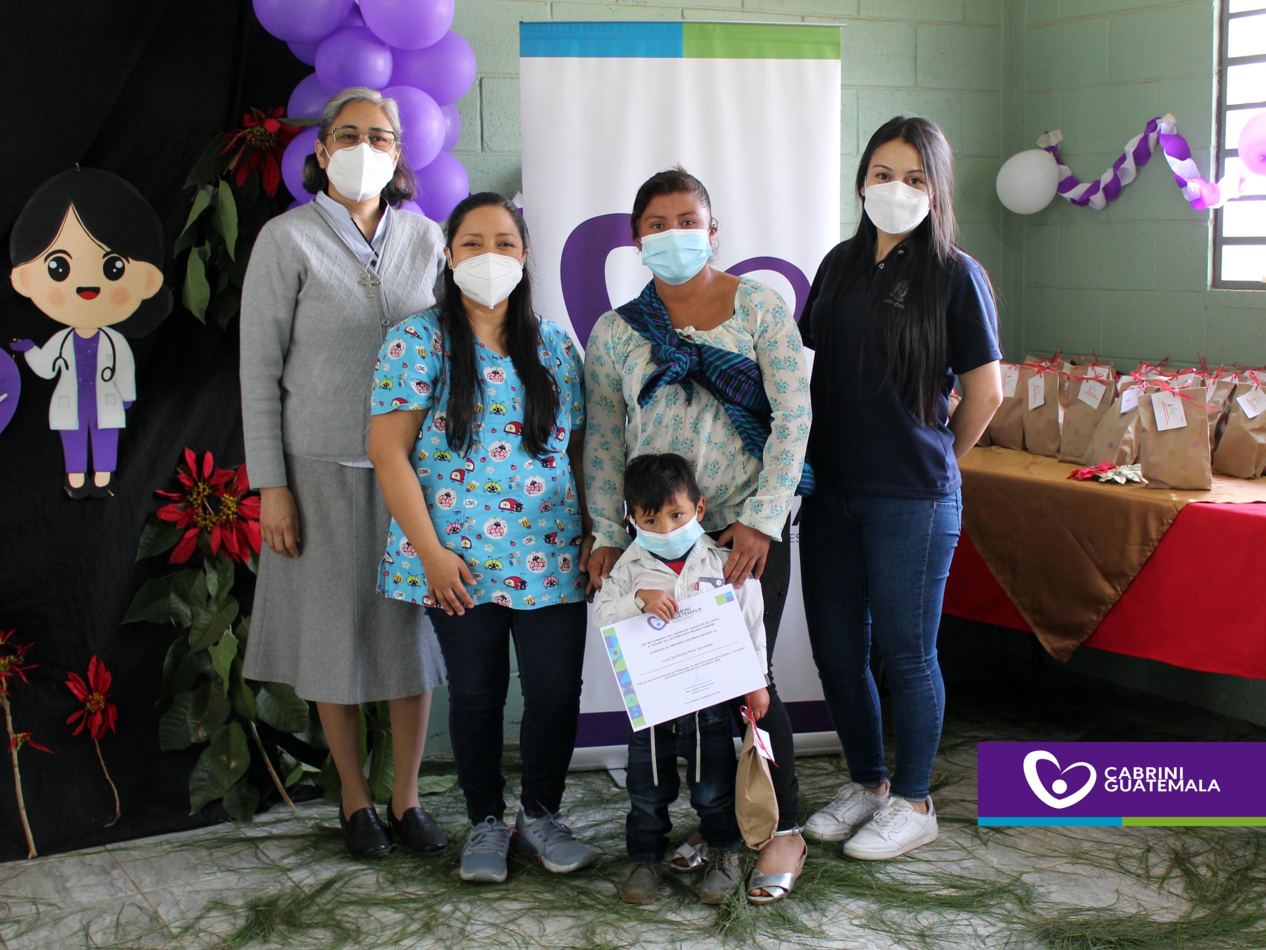 Women and a small boy holding donations to the Cabrini Guatemala foundation