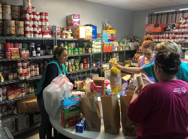 Canned goods and other Pantry donations being parceled into bags