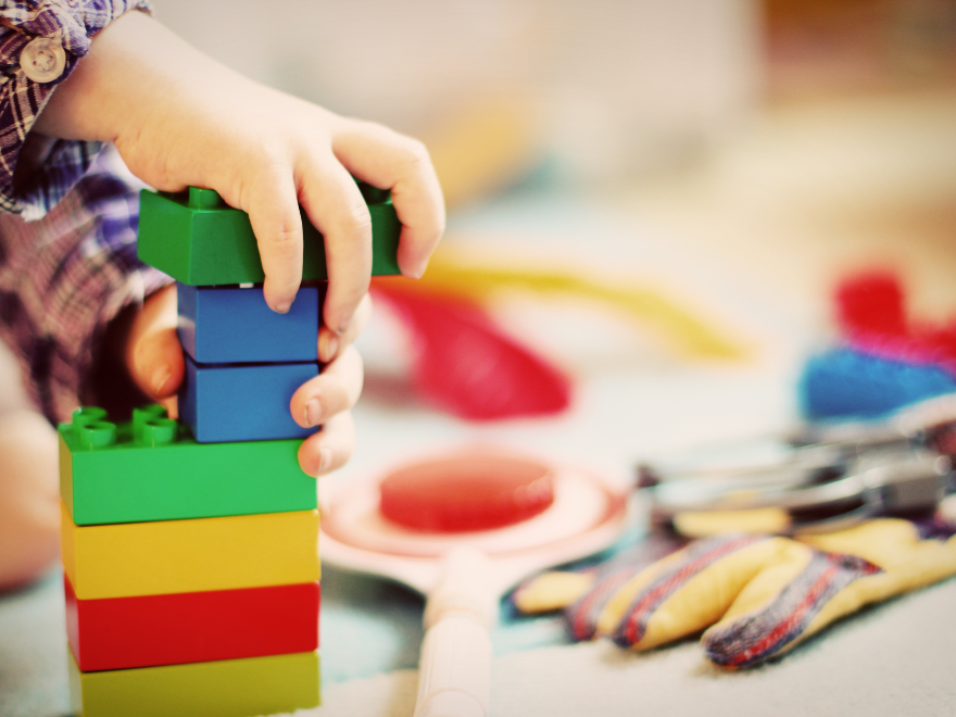 Small child's hands stacking colorful blocks