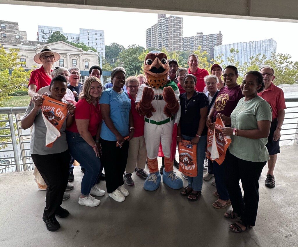 Cabrini employees pose with the Staten Island FerryHawks mascot